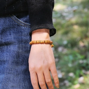 Pulsera elástica de cuentas de madera natural con textura rústica usada en la muñeca