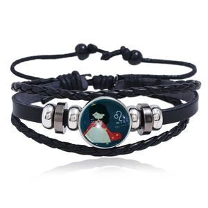 Close-up of multilayer leather bracelet featuring a Leo zodiac luminous glass cabochon