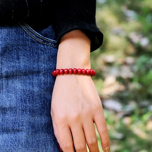 Pulsera minimalista de cuentas de madera roja para hombres y mujeres mostrada en la muñeca