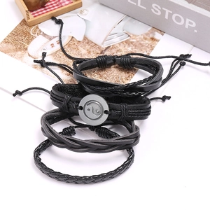Four-piece set of black braided leather bracelets with Yin Yang alloy charm and adjustable cords
