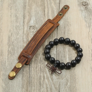Vintage brown leather cuff bracelet with metal snaps and black wood bead stack