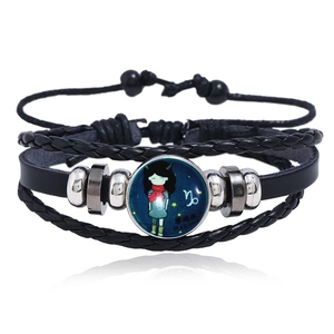 Close-up of multilayer leather bracelet with glowing Capricorn sign glass gem