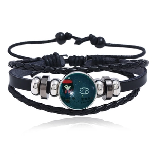 Macro shot of Cancer zodiac sign cabochon on braided leather multilayer bracelet