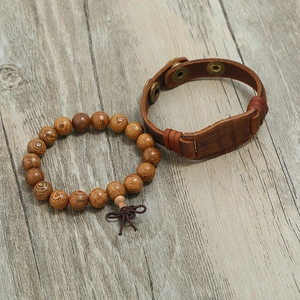 Men's retro wooden beads and brown leather bracelet set on a natural wood surface