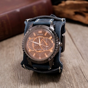 Macro shot of dark blue leather cuff watch band with precise white stitching and wood background