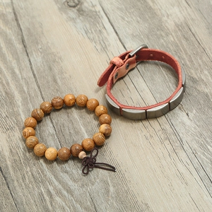 Set di bracciale vintage in pelle e perline di legno su superficie in legno naturale