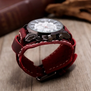 Gros plan sur une montre en cuir large avec coutures blanches et boîtier vintage