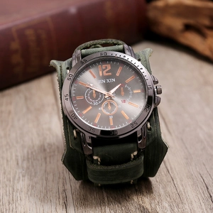 Gros plan d'une montre de style armée rétro avec large bracelet en cuir vert et cadran en métal