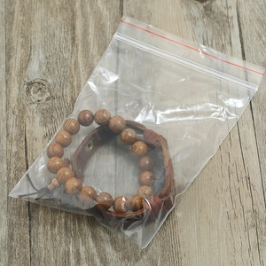 Detail view of men's wooden beaded bracelet and brown leather band set in packaging