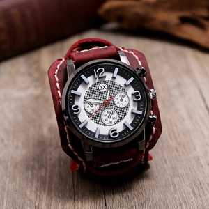 Gros plan d'une montre punk vintage avec bracelet en cuir rouge foncé et coutures blanches