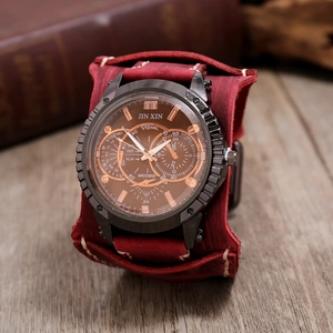 Macro shot of retro men's chronograph watch with a wide red leather punk style wristband