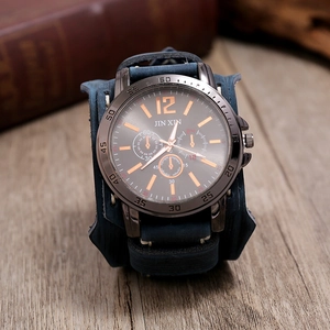 Détail du bracelet en cuir bleu foncé avec coutures et cadran en métal gris foncé de montre