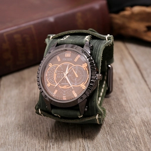 Macro shot of men's vintage leather watch with dark green band on rustic wooden desk