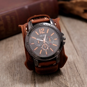 Détail du bracelet en cuir marron vintage avec surpiqûres et grand cadran de montre noir