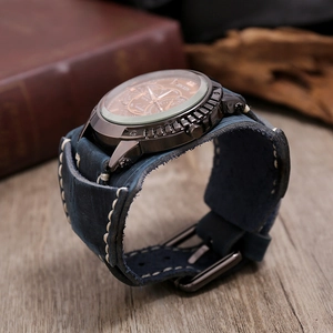 Detail of vintage blue leather wide strap watch with bronze dial and industrial gear casing