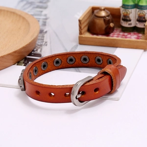 Detailed macro view of the brown leather wristband with silver buckle and adjustment holes
