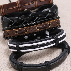 Macro shot of vintage braided leather bracelet set with metallic eyelets on burlap