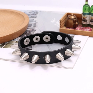 Detail of adjustable snap buttons on a black punk leather bracelet with silver metal spikes