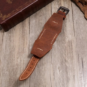 Gros plan du bracelet de montre en cuir marron avec couture blanche et boucle noire