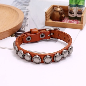 Detailed close-up of brown vintage leather bracelet with silver embossed metal rivets