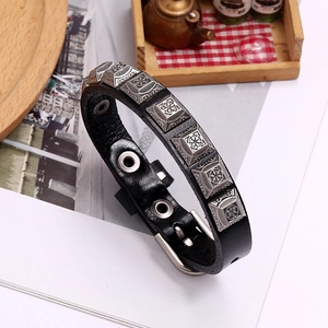 Detail of vintage black leather punk bracelet with embossed silver square rivets and buckle