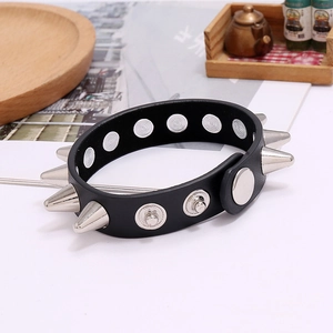 Macro detail of punk leather bracelet with double-row silver metal spikes and snap buckle