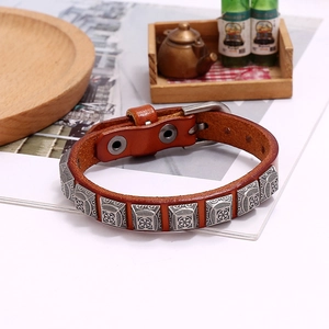 Detail of vintage brown leather punk bracelet with square silver rivets and buckle