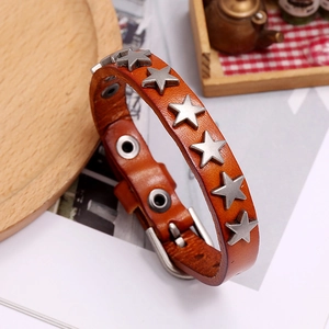 Macro detail of brown leather punk bracelet with silver star rivets and buckle closure