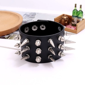 Detail view of wide black punk leather bracelet with three rows of silver metal spikes
