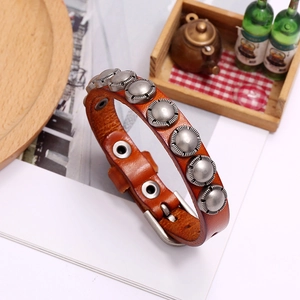 Macro detail of vintage punk leather bracelet with silver rivets and snap button closure