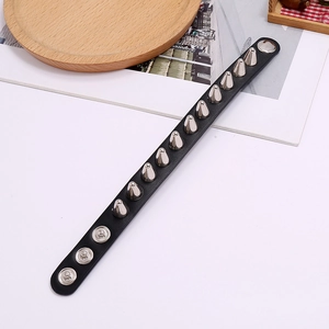Detail showing black punk leather bracelet with silver metal spikes and snap fasteners