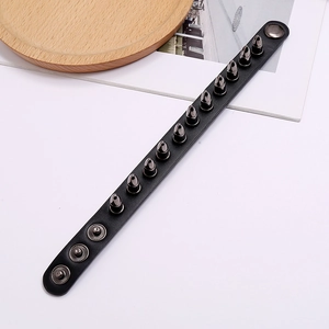 Detail of punk leather bracelet with twelve gunmetal bullet spikes and snap fasteners