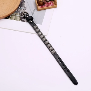 Detail of black punk leather bracelet with silver cross square studs and buckle strap