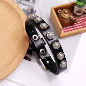 Detail eines schwarzen Lederarmbands mit industriellen silbernen Sechskantmuttern und Schnalle