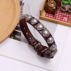 Close-up of vintage brown leather bracelet with silver metal studs and buckle strap