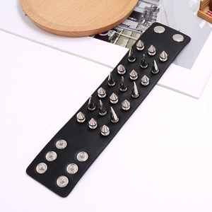 Detail view of adjustable metal snap buttons on black punk leather spiked bracelet