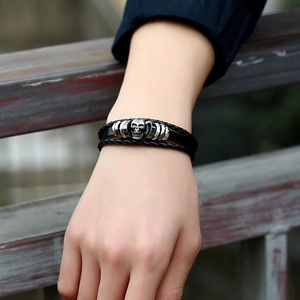 Men's vintage braided black leather bracelet featuring a silver metal skull centerpiece