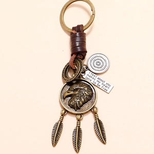 Vintage eagle emblem leather keychain with hanging feathers and engraved metal quote plate