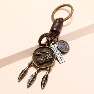 Vintage eagle and feather pendant keychain made of bronze metal and woven brown leather