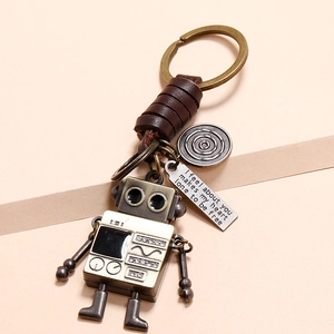 Retro robot leather keychain with bronze alloy finish and woven cord detail on beige base
