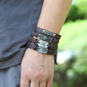 Détail d'un ensemble de 4 bracelets en cuir avec motifs de croix, tête de mort et texte