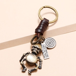 Vintage bronze skeleton robot keychain with brown braided leather strap and engraved tag