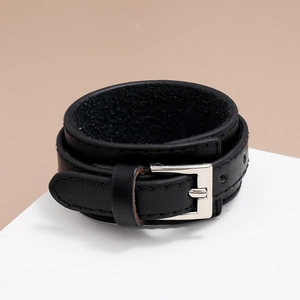 Macro detail of black PU leather bracelet showing adjustable silver buckle and grain texture