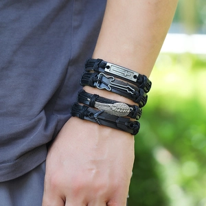 Detail of men's black braided leather bracelets with cross and guitar metal charms