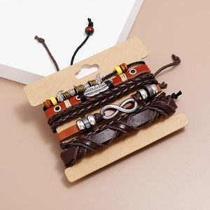 Macro detail of multi-layer leather bracelets with metal feather and infinity charms