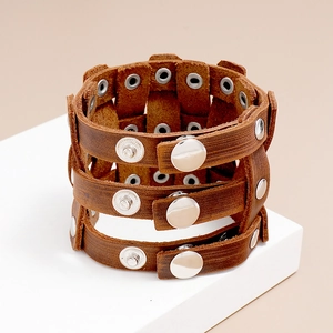 Macro detail of vintage brown leather bracelet texture with silver studs and metal buckles