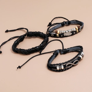 Detail view of vintage black braided leather bracelets with infinity and feather charms