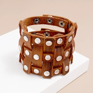 Detail of vintage wide leather wristband with three rows of silver metal rivets