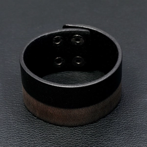 Detail of dual-layer black and brown leather wide wristband with four metal snap buttons