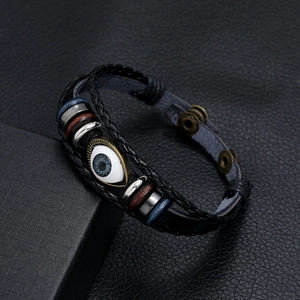 Close-up of woven leather evil eye bracelet with bronze spacers and wooden beads